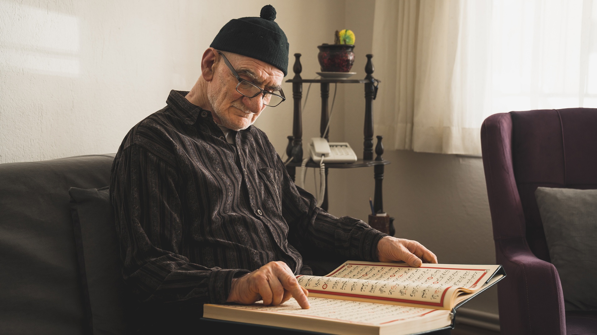 Muslim liest in seiner Wohnung im Koran 