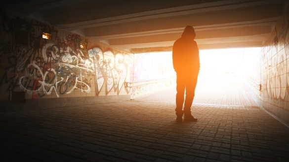 Silhouette eines jungen Mannes in einer Bahnunterführung mit Graffity.