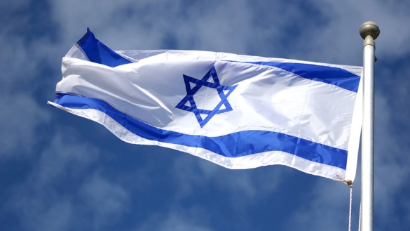 Flagge von Israel mit Davidstern vor blauem Himmel.