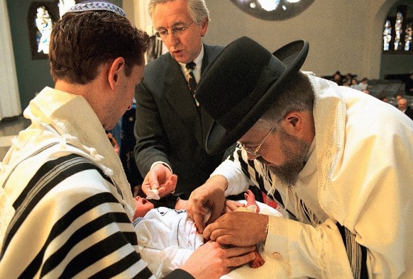 Ein jüdischer Beschneider bei der Beschneidung eines jüdischen Jungen.