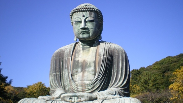 Buddha aus hellgrauem Stein mit im Schoß nach oben geöffneten Händen.