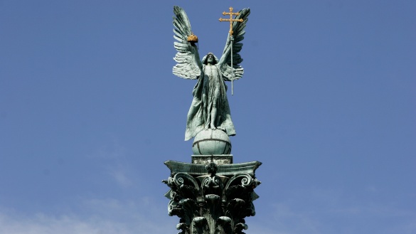Erzengel Gabriel auf der Säule des Milleniumsdenkmals auf dem Heldenplatz in Budapest vor blauem Himmel.