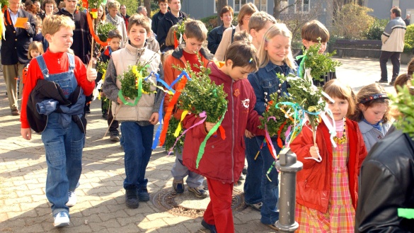 Palmsonntagsfeier in Mainz. Kinder und Erwachsene laufen am Palmsonntag mit Palmsträußen zur Messe ins katholische Pfarrzentrum Mainz-Laubenheim.