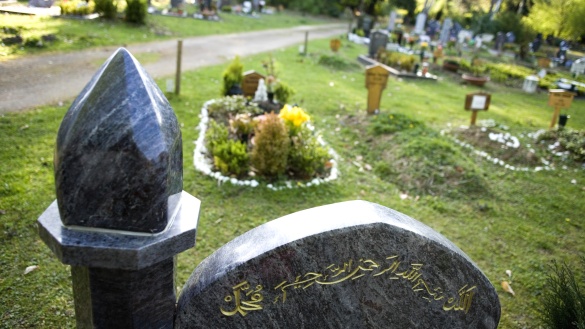 Dunkelgraue Grabsteine mit arabischen Schriftzeichen auf einem deutschen Friedhof.