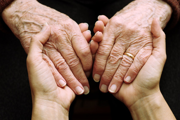 In den Händen eines jungen Menschen liegen die Händes eines alten Menschen. 