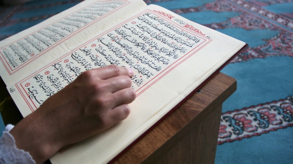 Die Hand eines Menschen, der im Koran liest