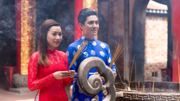 Vietnamesische Frau und Mann mit Räucherstäbchen